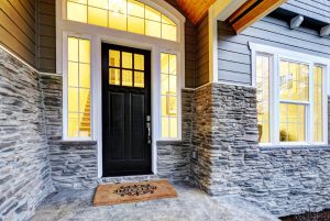 A modern black front entry door on a luxury home.