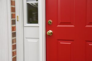 A durable red steel entry door with a sidelite