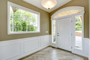 Entrance hallway with tile floor and beige wall with white trim. 
